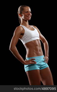 Fitness woman smiling. Fitness woman smiling standing against black background