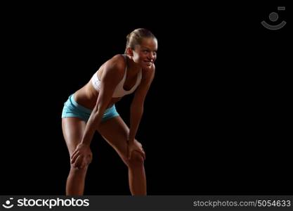 Fitness woman smiling. Fitness woman smiling standing against black background