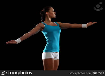 Fitness woman smiling standing against black background