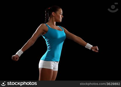 Fitness woman smiling standing against black background