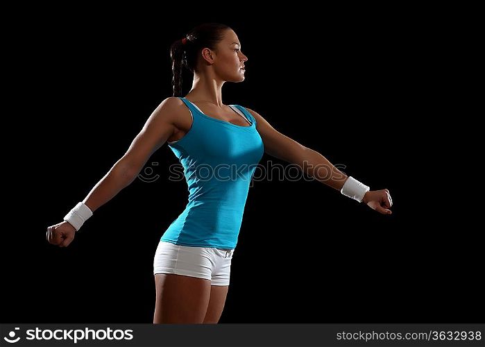 Fitness woman smiling standing against black background