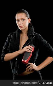 Fitness woman standing with towel and bottle on black background