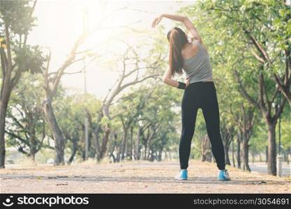 Fitness woman standing yoga posture on the street. Among the trees and nature The morning sun is shining, exercise ideas for health.