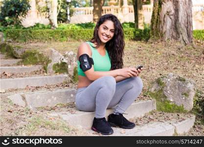 Fitness woman using smartphone in the park