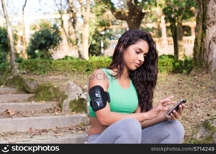 Fitness woman using smartphone in the park