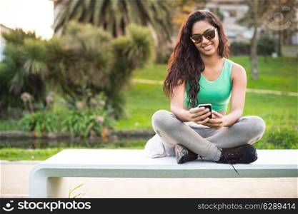 Fitness woman with smartphone at city park