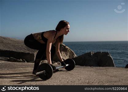 Fitness woman with tattoos lifting weights - Outdoor