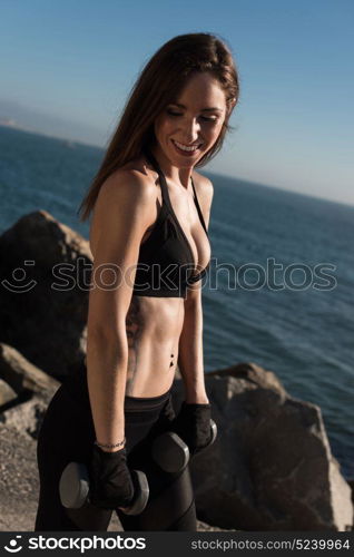 Fitness woman with tattoos lifting weights - Outdoor