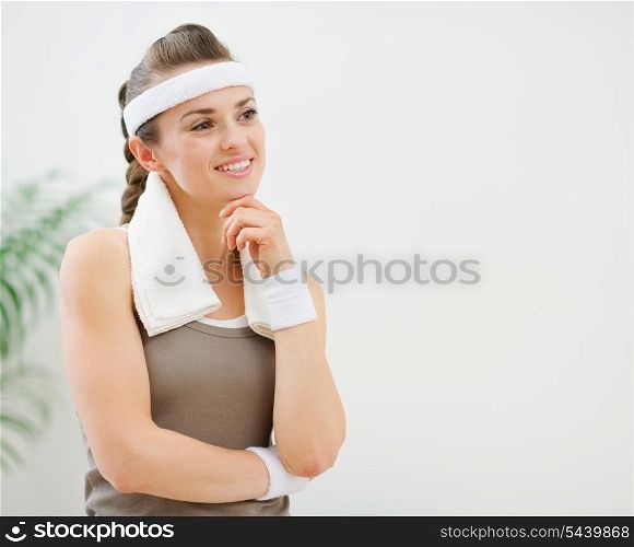 Fitness woman with towel on shoulders looking on copy space