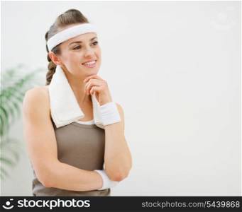 Fitness woman with towel on shoulders looking on copy space