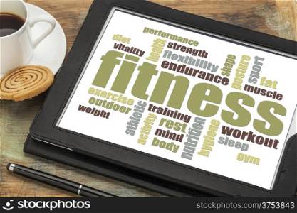 fitness word cloud on a digital tablet with a cup of coffee