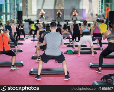 Fitness Workout in Gym: People doing Exercises in Class with Step Platform, Music and Teacher on Stage.. Fitness Workout in Gym: People doing Exercises in Class with Step Platform, Music and Teacher on Stage