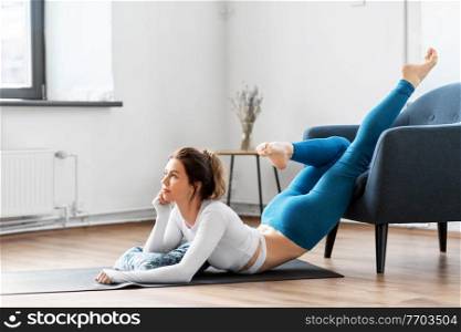 fitness, yoga and healthy lifestyle concept - young woman stretching at home. young woman stretching and doing yoga at home