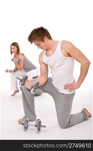 Fitness - Young healthy couple exercise with metal weights on white background