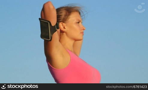 Fitness young woman looking away against blue sky after exercise outdoors