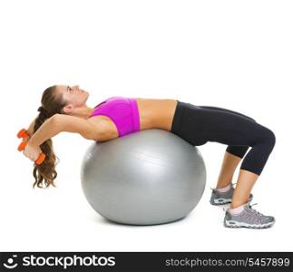Fitness young woman making exercise with dumbbells on fitness ball