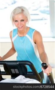 Fitness young woman on elliptical cross trainer at health gym