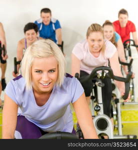 Fitness young woman on gym bike spinning indoor cardio exercise
