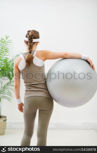 Fitness young woman with fitness ball. Rear view