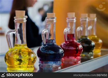 five bottles of different color food coloring on the shop window, selective focus.. five bottles of different color food coloring on the shop window, selective focus
