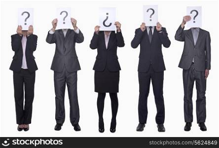 Five business people holding up paper with question mark, obscured face, studio shot