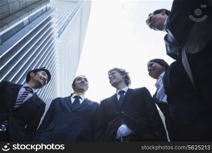 Five business people standing outdoors talking and smiling, Beijing, Low angle view