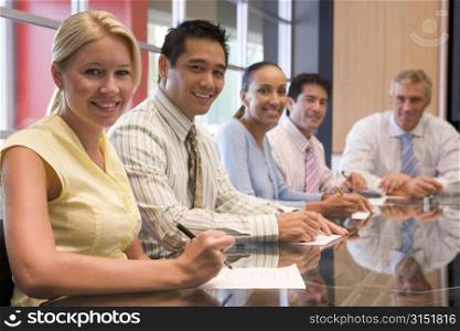 Five businesspeople in boardroom smiling