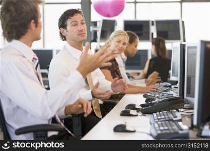Five businesspeople in office space with a ball being thrown