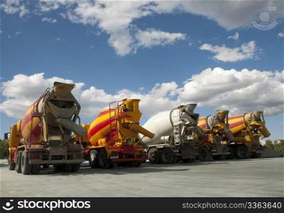 Five Cement Trucks on blue sky
