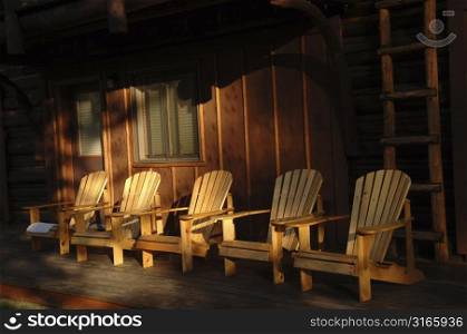 Five empty chairs on a deck