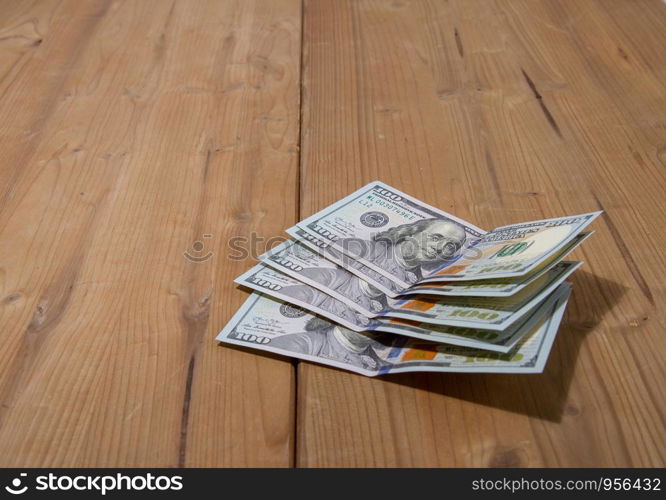 five hundred dollar bills lying on a rough wooden surface. five hundred dollars