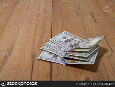 five hundred dollar bills lying on a rough wooden surface. five hundred dollars