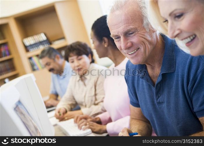 Five people at computer terminals in library (depth of field)
