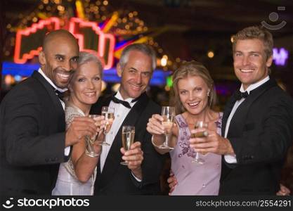 Five people in casino with champagne smiling (selective focus)