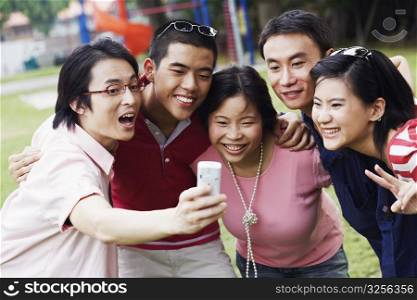 Five people looking at a mobile phone