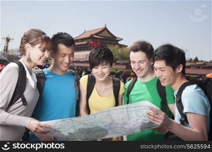 Five people looking at map with Tiananmen Square in background.