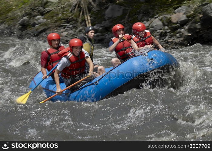 Five people rafting in a river