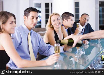Five people sitting at a bar counter