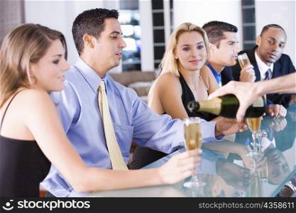 Five people sitting at a bar counter