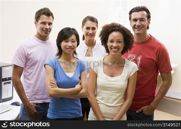 Five people standing in computer room smiling