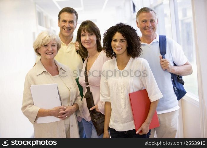 Five people standing in corridor with books (high key)