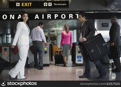 Five people walking at an airport