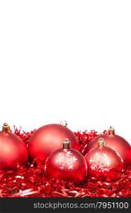 five red Xmas balls and tinsel isolated on white background