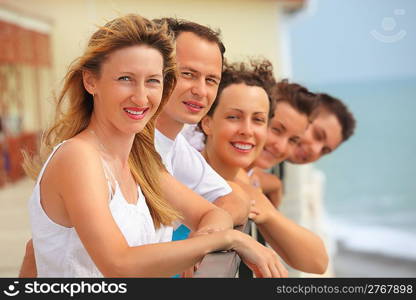 Five smiling friends on balcony