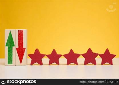 Five stars on wooden cubes, yellow background. Service evaluation concept, high rating