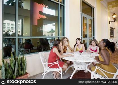 Five teenage girls sitting together and discussing