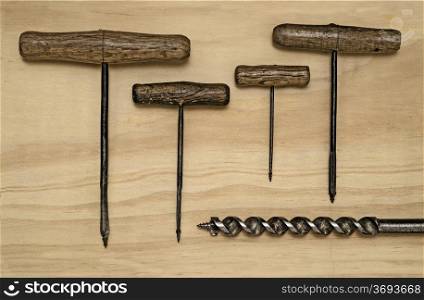 Five Vintage Hand drills of various sizes on a wooden background