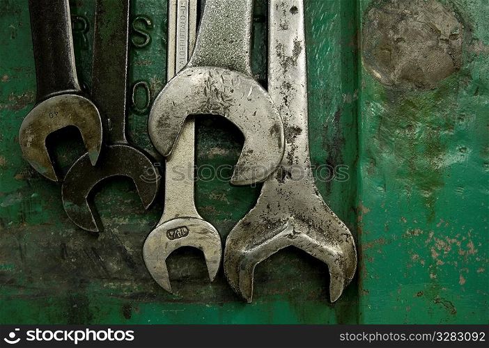 Five wrenches hanging in machine shop.
