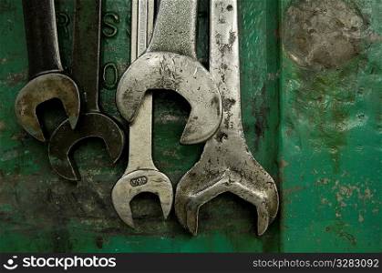 Five wrenches hanging in machine shop.
