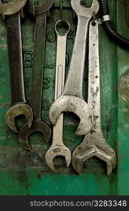 Five wrenches hanging in machine shop.